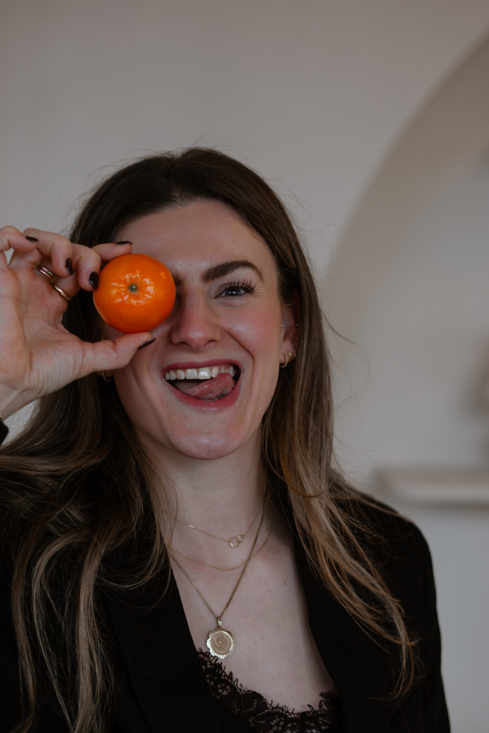 Lotte lacht met een sinaasappel voor haar oog